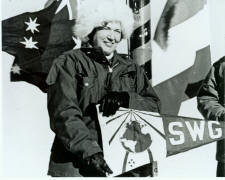 Jackie poses at the South Pole with Society of Woman Geographer's flag, in 1971.  Navy photo